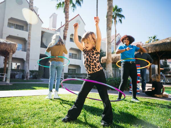 Two kids and a team member hula hooping at Desert Club Resort in Las Vegas, Nevada.