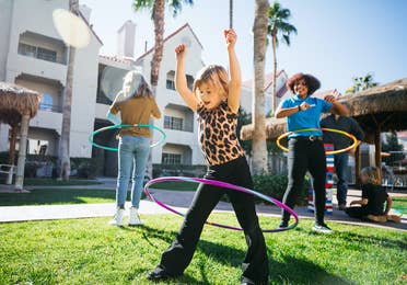 Two kids and a team member hula hooping at Desert Club Resort in Las Vegas, Nevada.