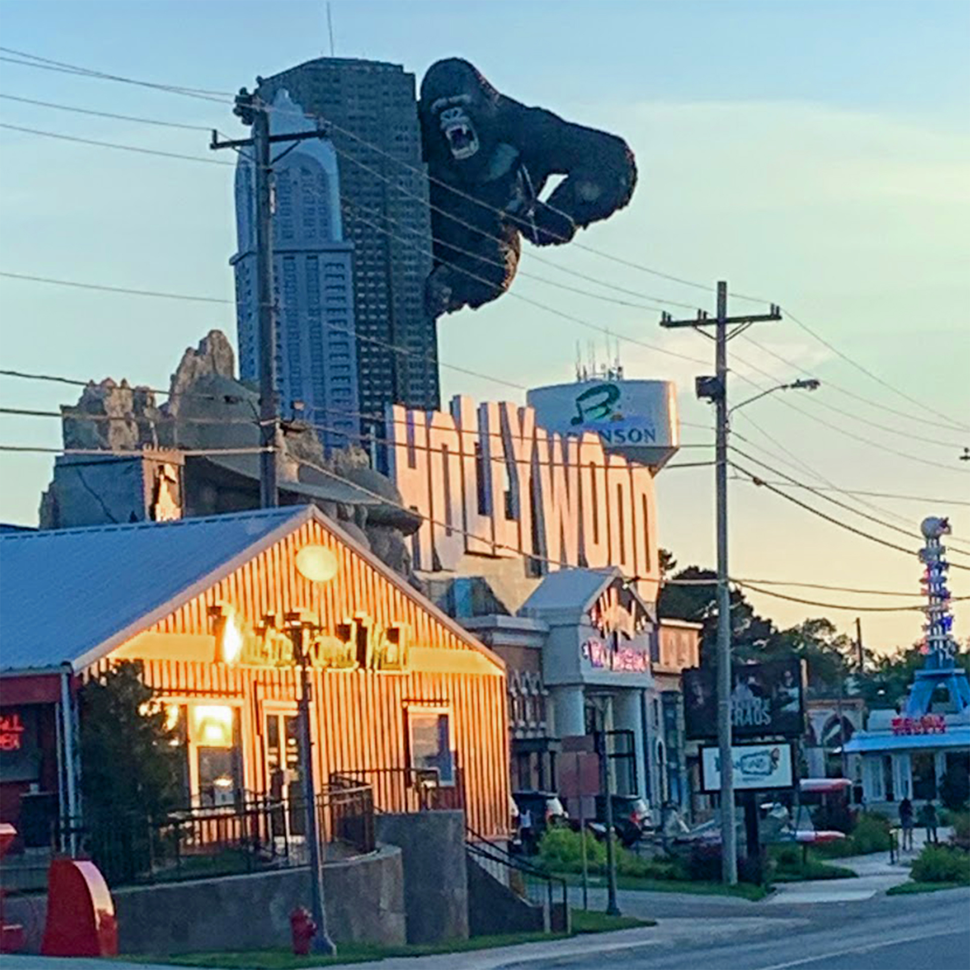 A figure of King Kong climbs a scaled skyscraper.