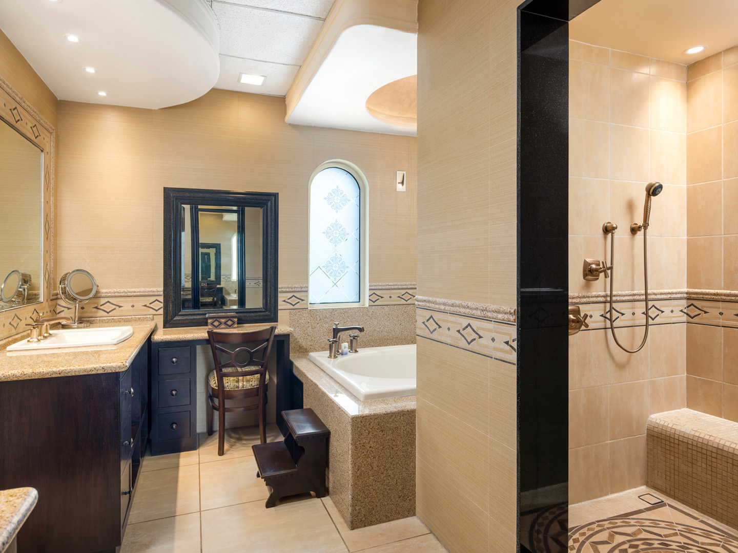 Upscale bathroom with stone counters, a tub, and a walk-in shower.