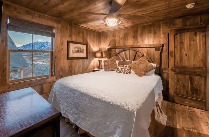 Second bedroom with a queen bed and view of the Sierra Nevada Mountains in a deluxe three-bedroom cottage at David Walley's Resort in Genoa, Nevada