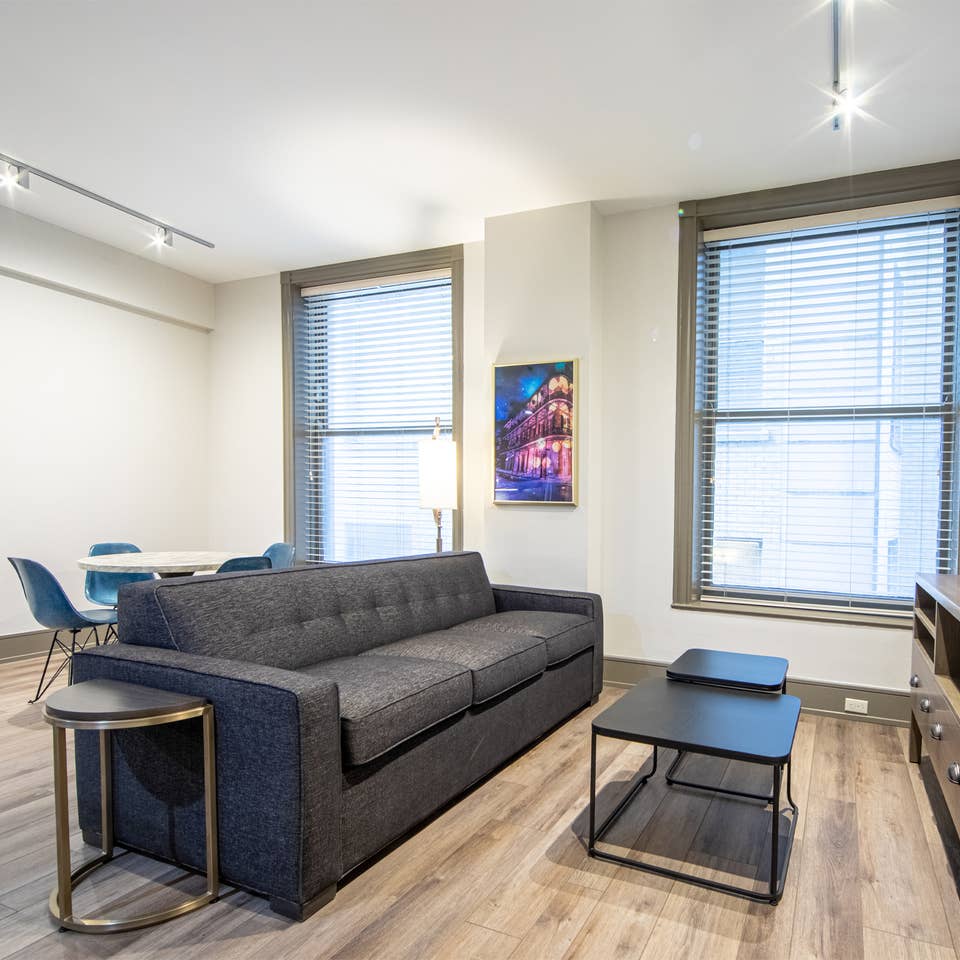 Two bedroom villa living area with couch, two windows and TV at New Orleans Resort in Louisiana.