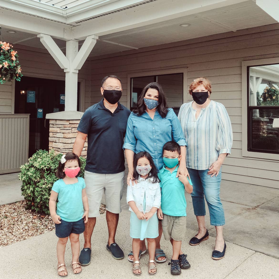 The Kajiwara family wearing masks outside of the Holiday Hills Resort.