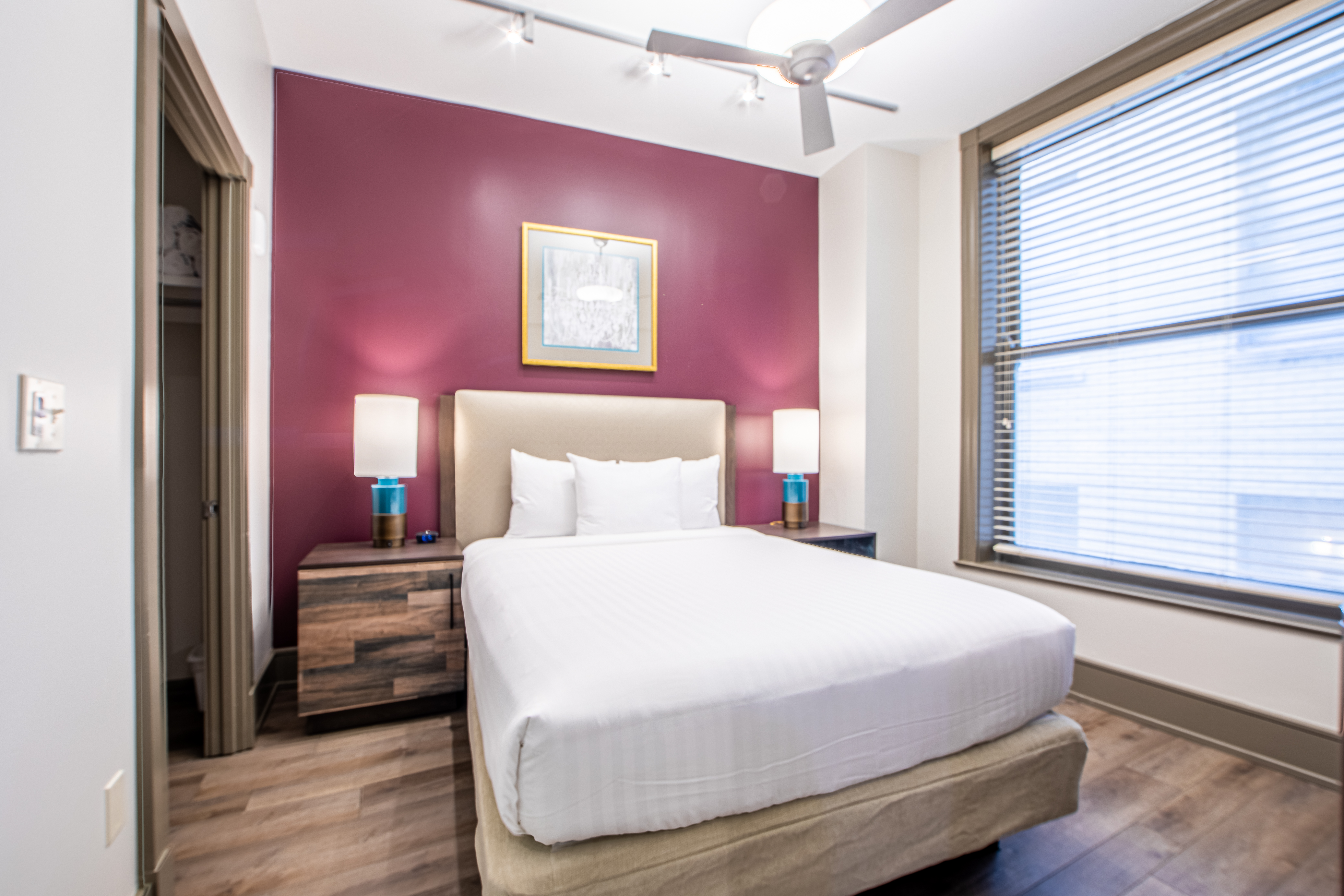 Two bedroom villa bedroom with bed, ceiling fan and large window at New Orleans Resort in Louisiana.