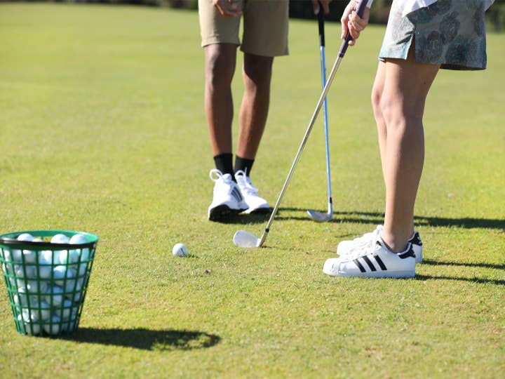 Two golfers putting.