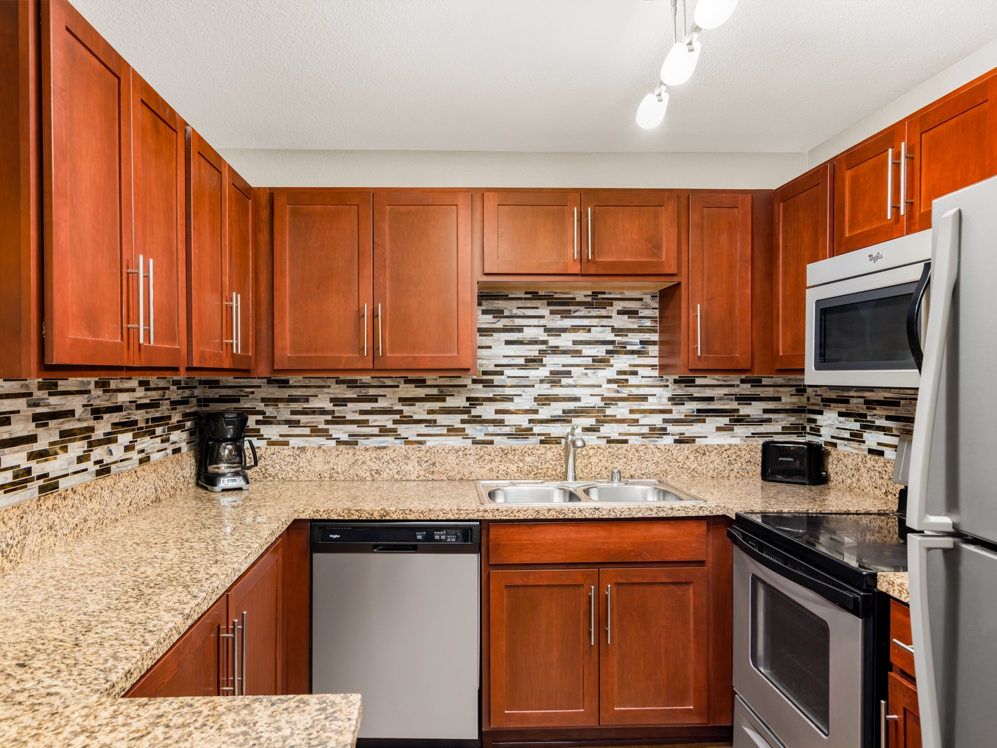 Stylish kitchen with modern appliances and mosaic backsplash.
