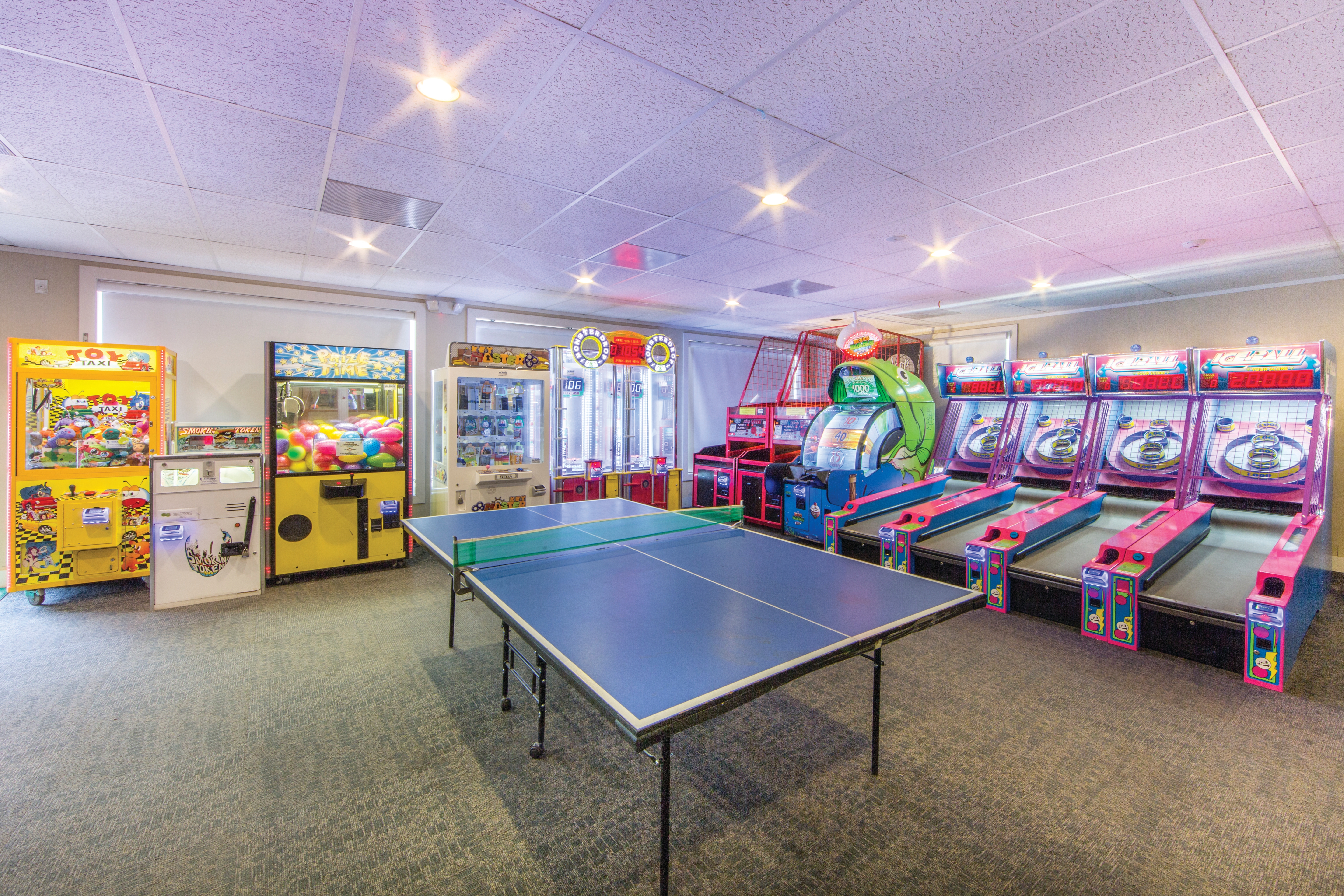 Game room at Oak n' Spruce Resort in South Lee, Massachusetts with table tennis, ski ball, and various other game machines.