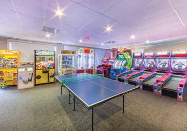 Game room at Oak n' Spruce Resort in South Lee, Massachusetts with table tennis, ski ball, and various other game machines.