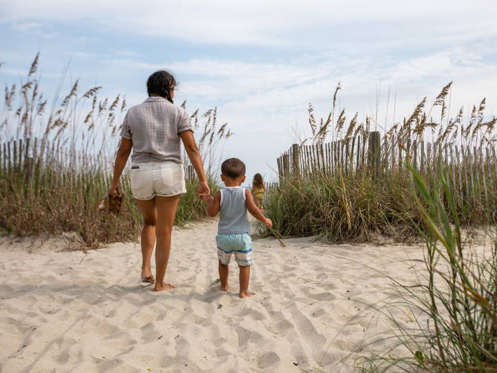 Adult and child walking onto beach at Cape Canaveral Beach Resort.