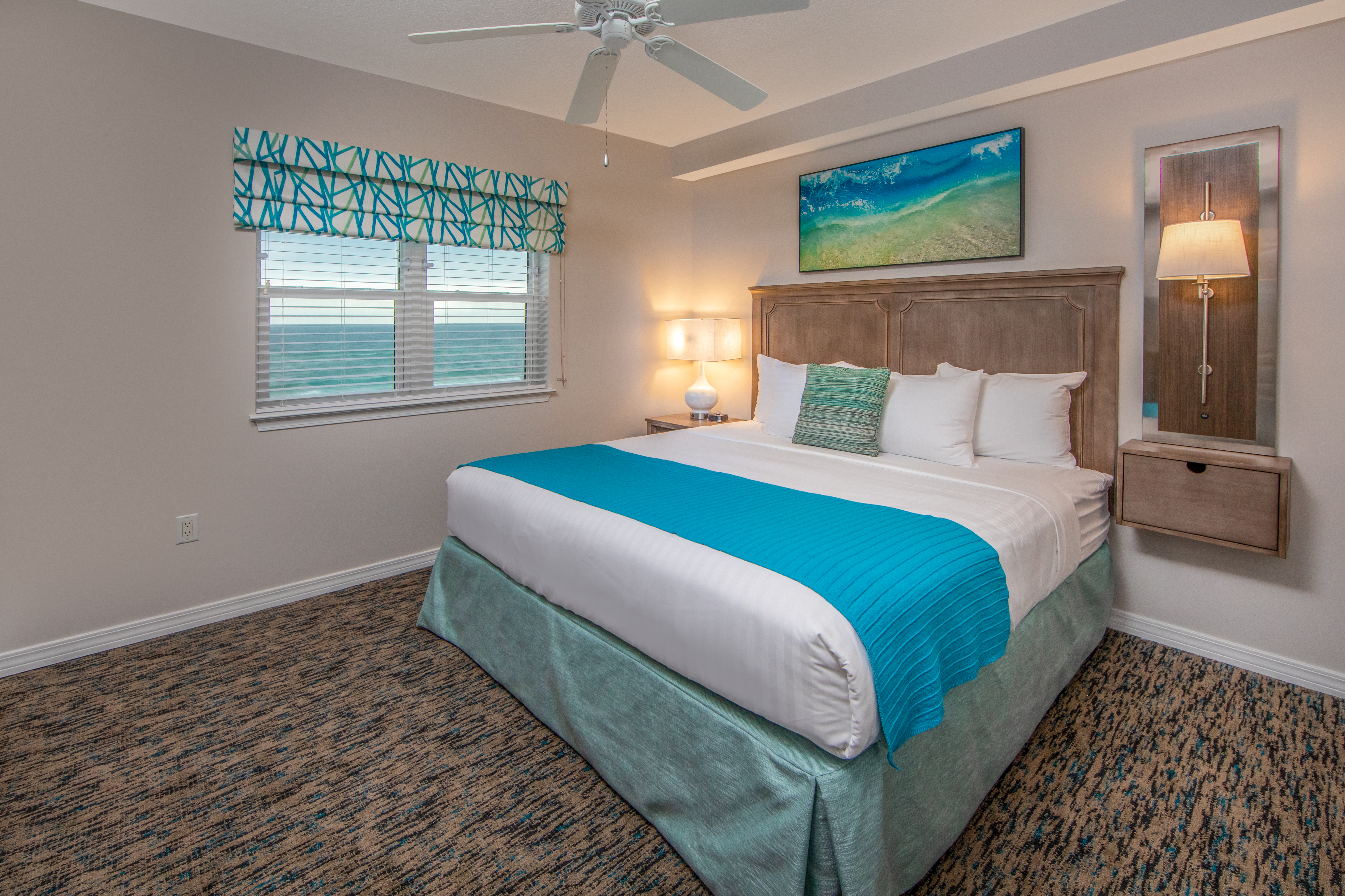 Bedroom with window with view of ocean and coastal decor in a two-bedroom villa at Panama City Beach Resort