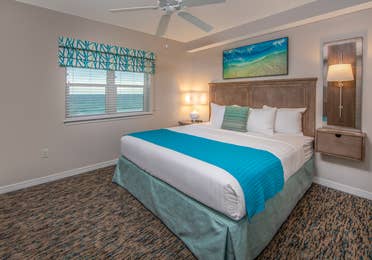 Bedroom with window with view of ocean and coastal decor in a two-bedroom villa at Panama City Beach Resort
