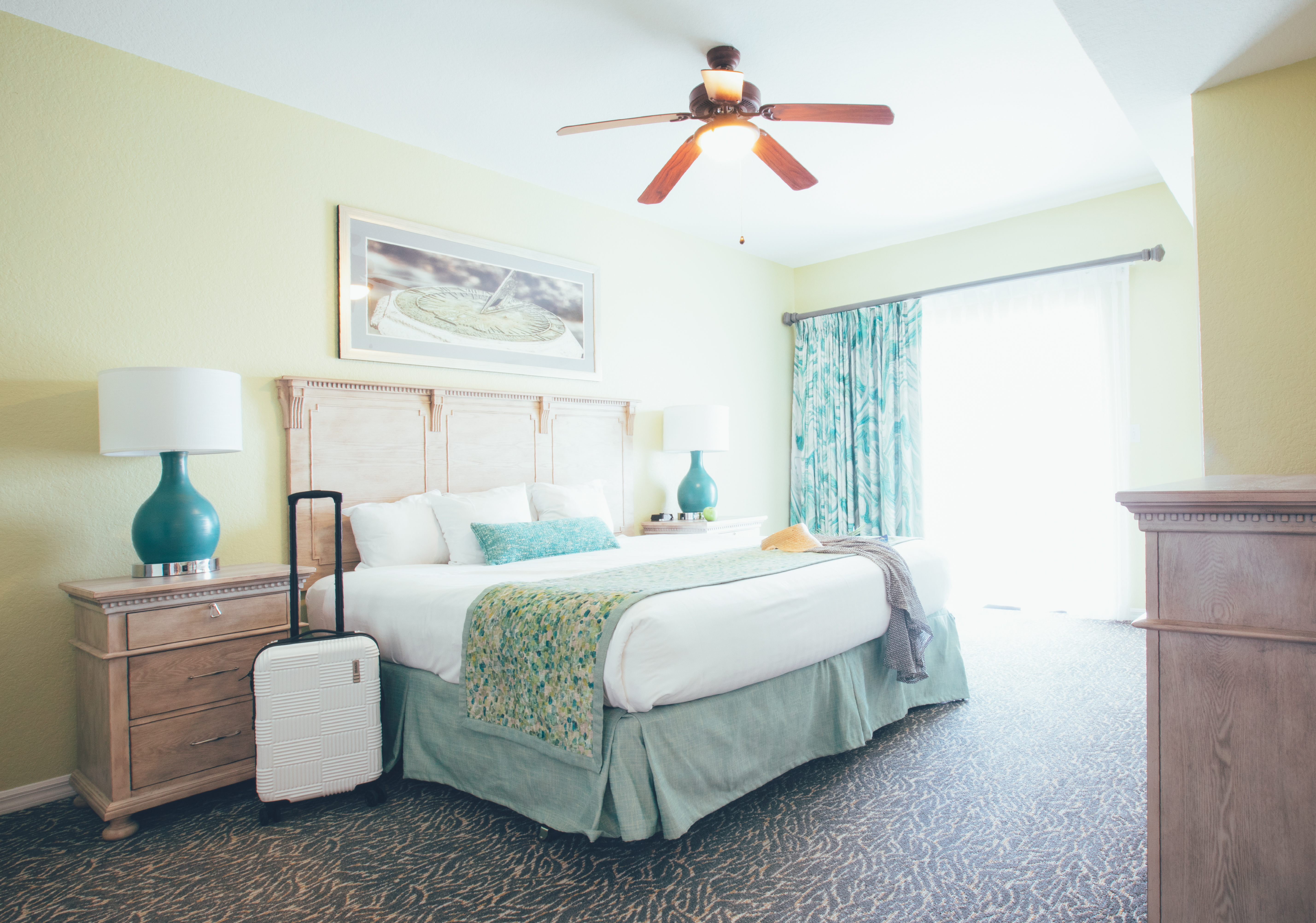 Bedroom with access to balcony and luggage in a villa in River Island at Orange Lake Resort near Orlando, Florida