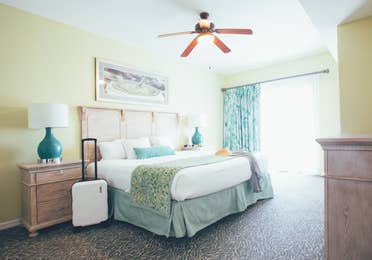 Bedroom with access to balcony and luggage in a villa in River Island at Orange Lake Resort near Orlando, Florida
