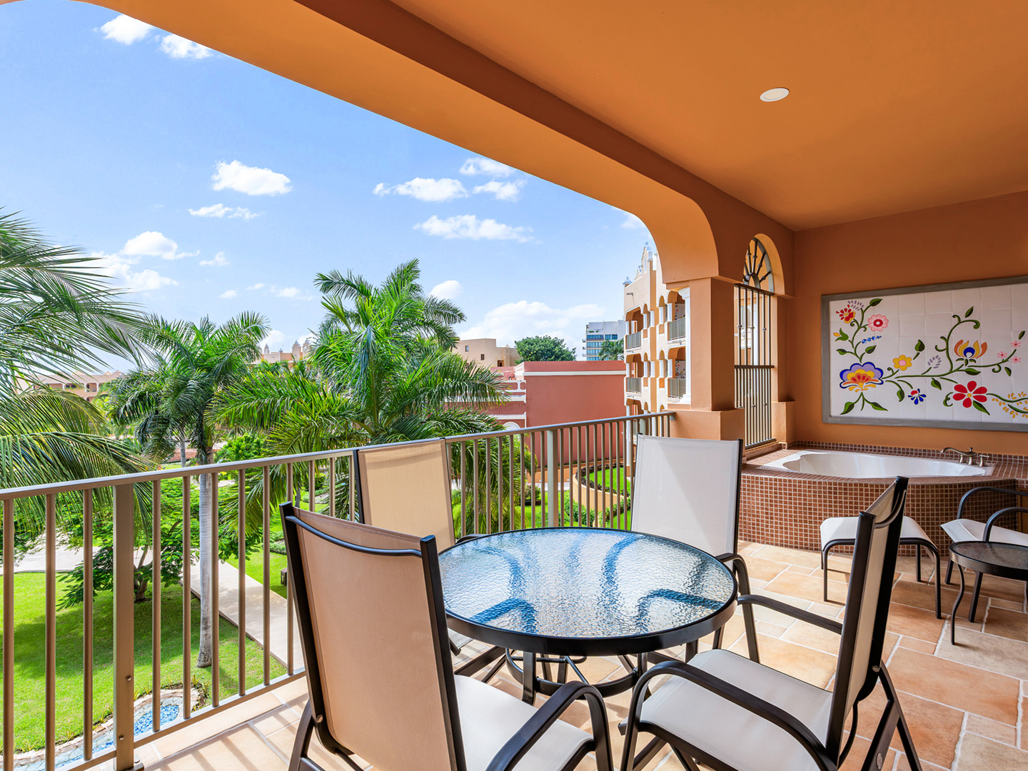 Garden-view balcony with dining set and soaking tub.