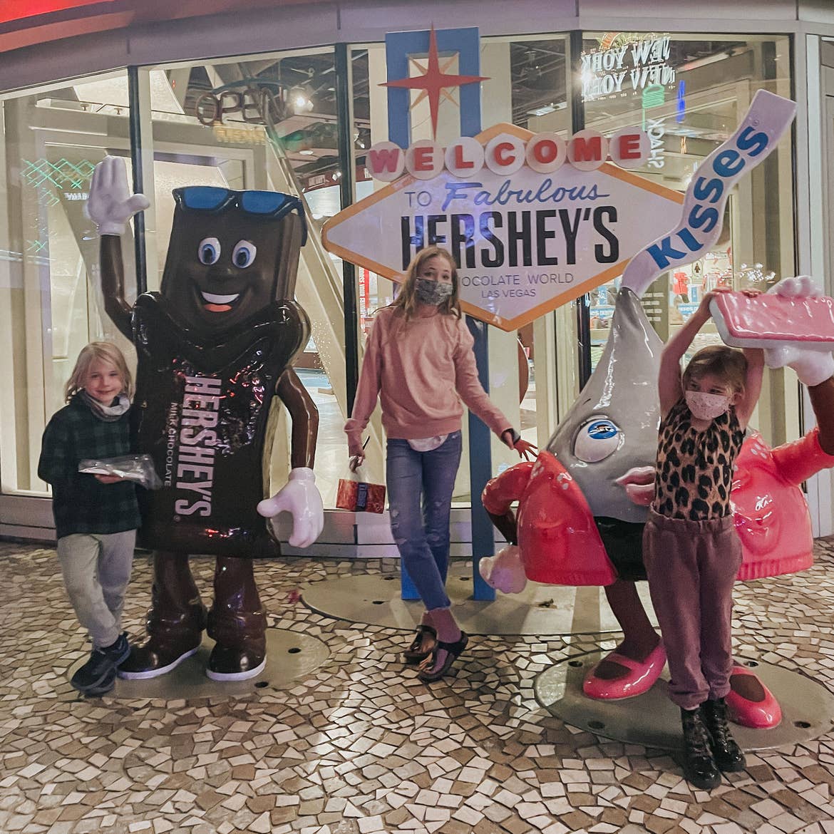 The Haby kids pose with character statues near a Las Vegas marquee replica that reads, 'Welcome to Fabulous Hershey's Chocolate World.'