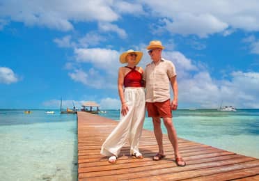 Couple standing on pier at the beach.