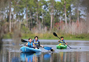 Kids kayaking in lake with watersport rentals at Orange Lake Resort near Orlando, Florida.