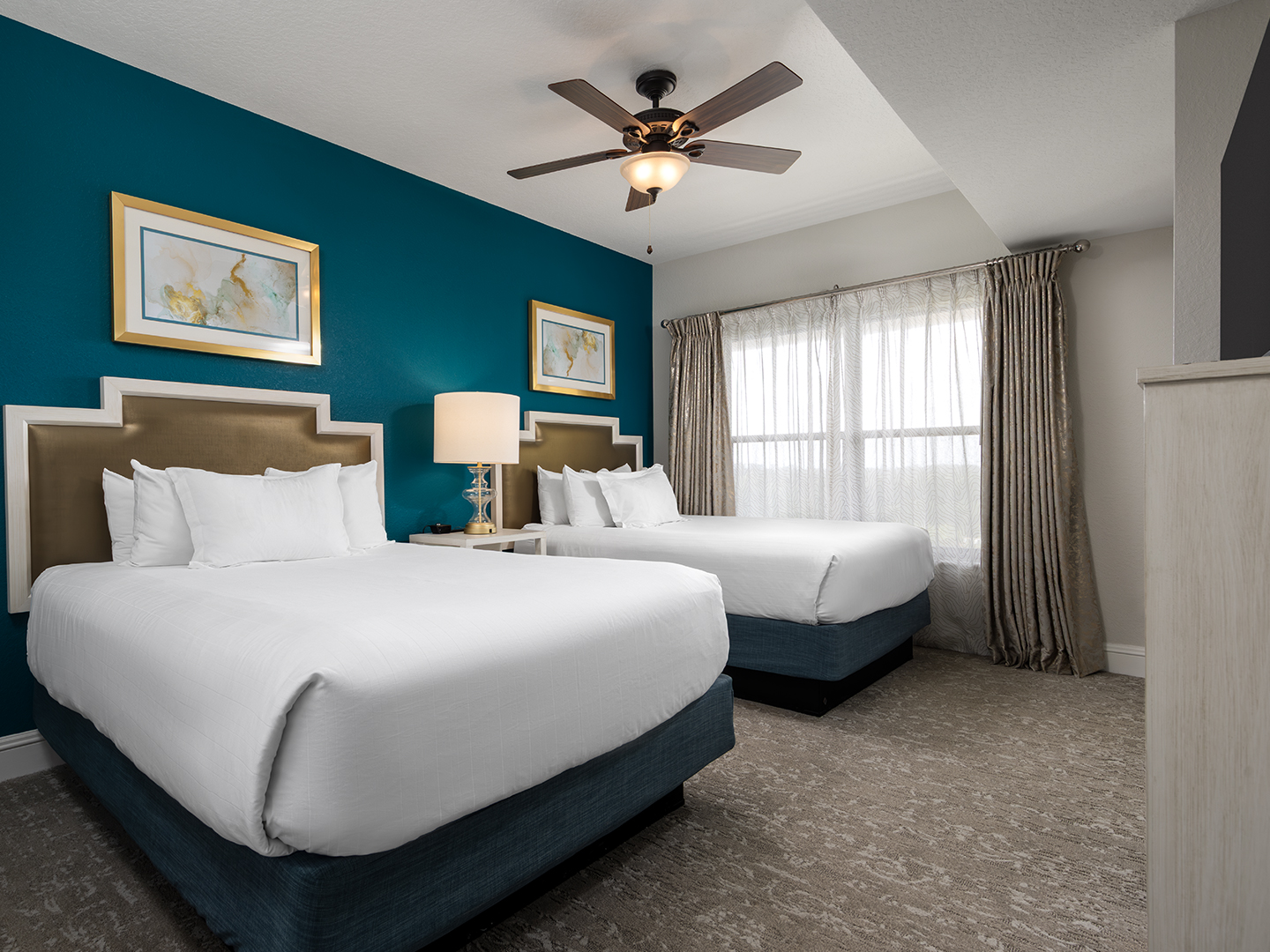 Resort bedroom with king bed, modern decor, and ceiling fan.