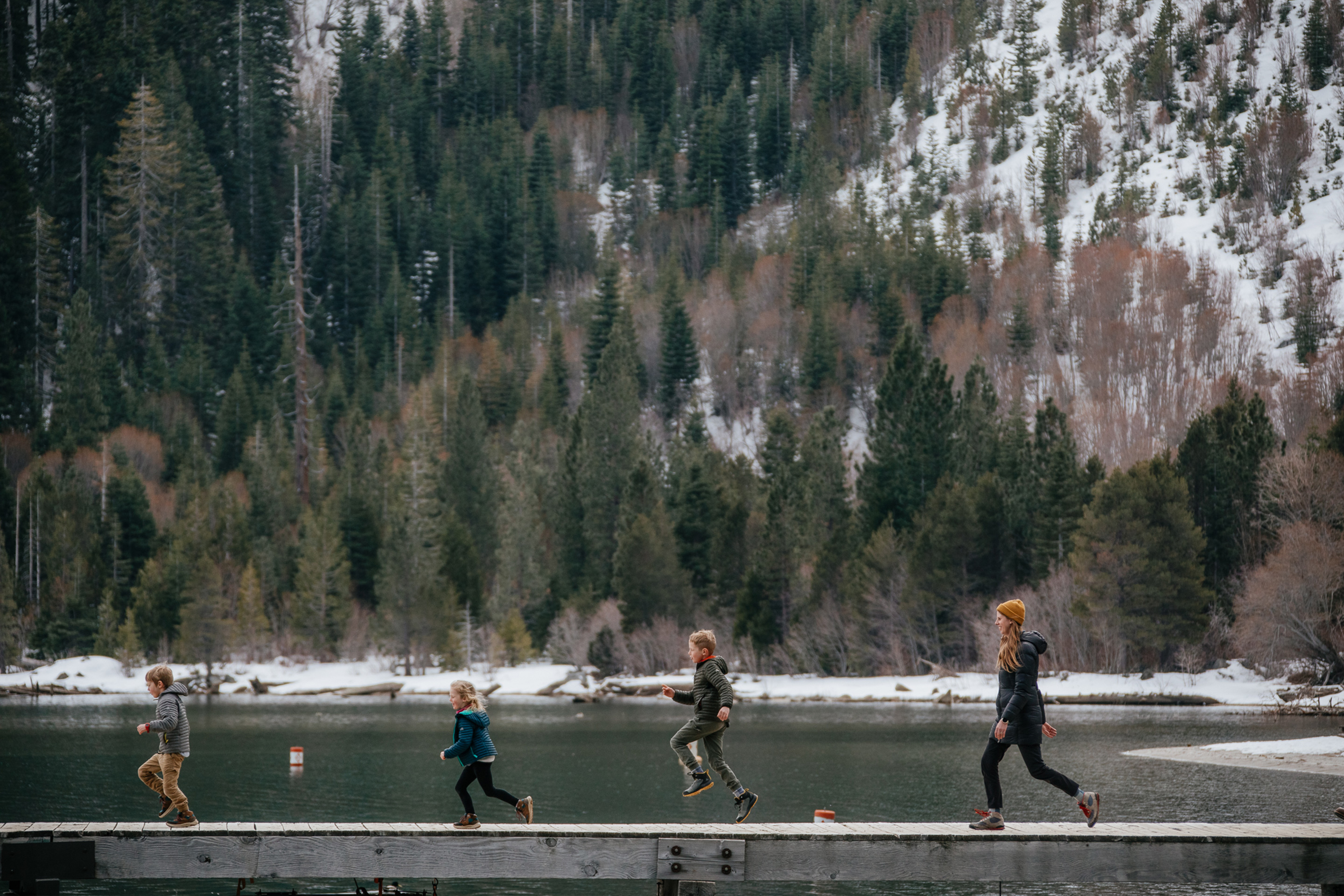 Featured Contributor, Andrea Rassmussen (right) and her children make their way down the dock surrounded by lush greenery.