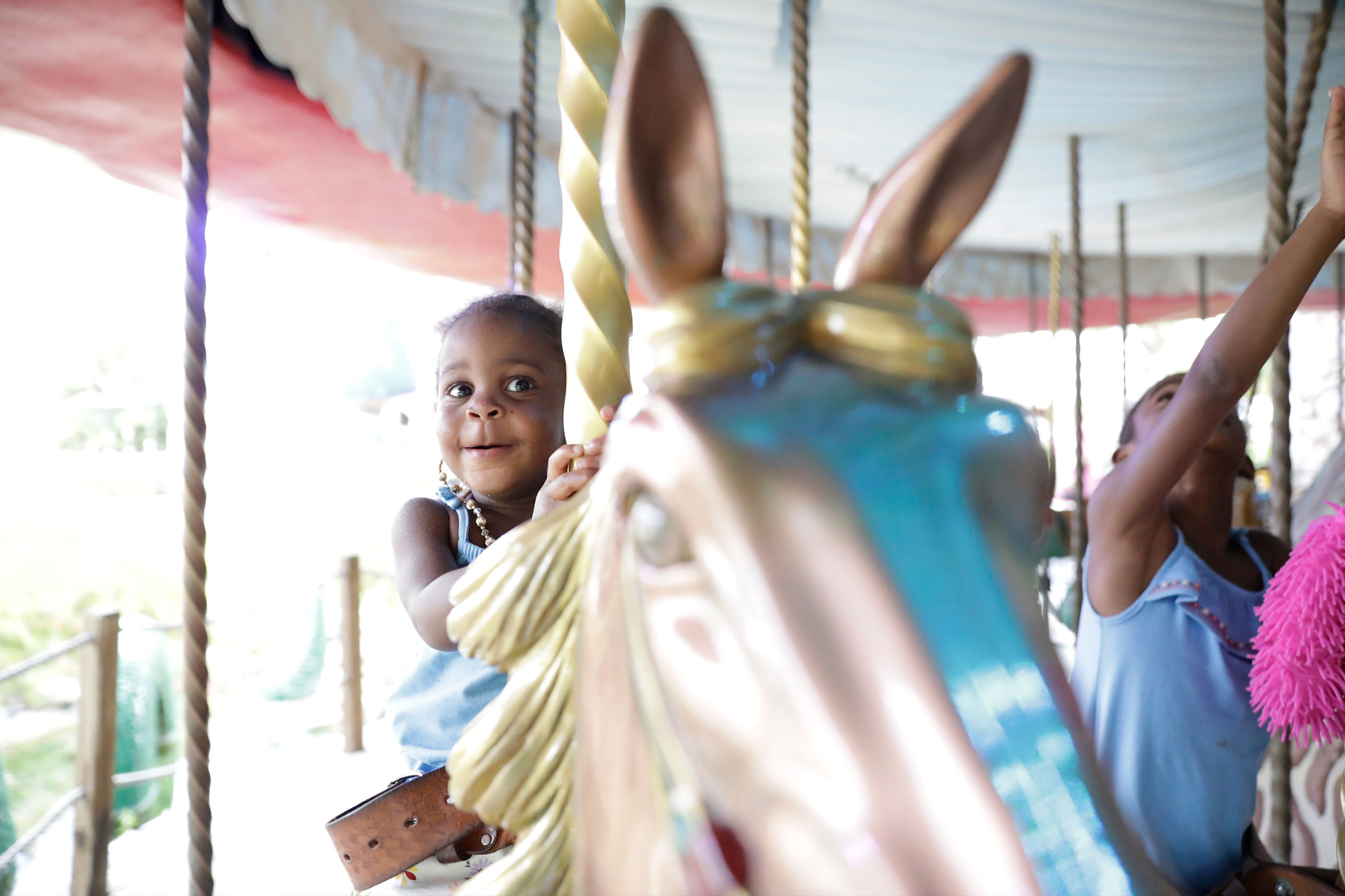 A Give Kids the World Villager rides a carousel in the Town Square (Photo take prior to COVID-19.)