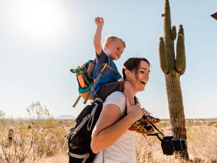 Young child on woman's shoulders in McDowell Sonoran Preserve near Scottsdale Resort.