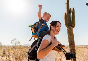 Young child on woman's shoulders in McDowell Sonoran Preserve near Scottsdale Resort.