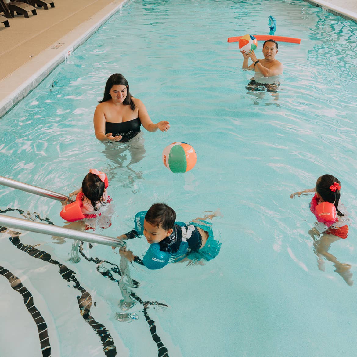 Featured Contributor, Angelica Kajiwara (left), and her family swim in a pool wearing swimming floaties at our Williamsburg resort in Williamsburg, Virginia.