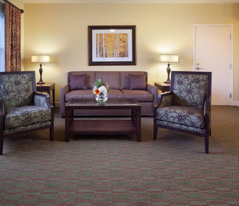 Living room with couch and two accent chairs in a one-bedroom villa at Lake Geneva Resort