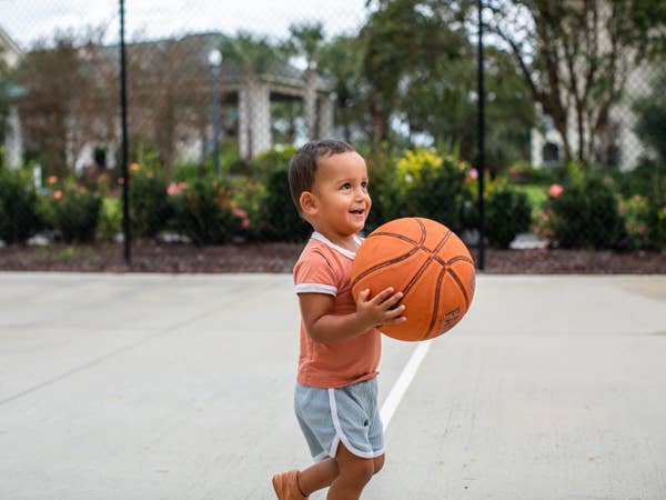 Young child holding basketball on basketball court at South Beach Resort in Myrtle Beach, South Carolina