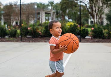 Young child holding basketball on basketball court at South Beach Resort in Myrtle Beach, South Carolina