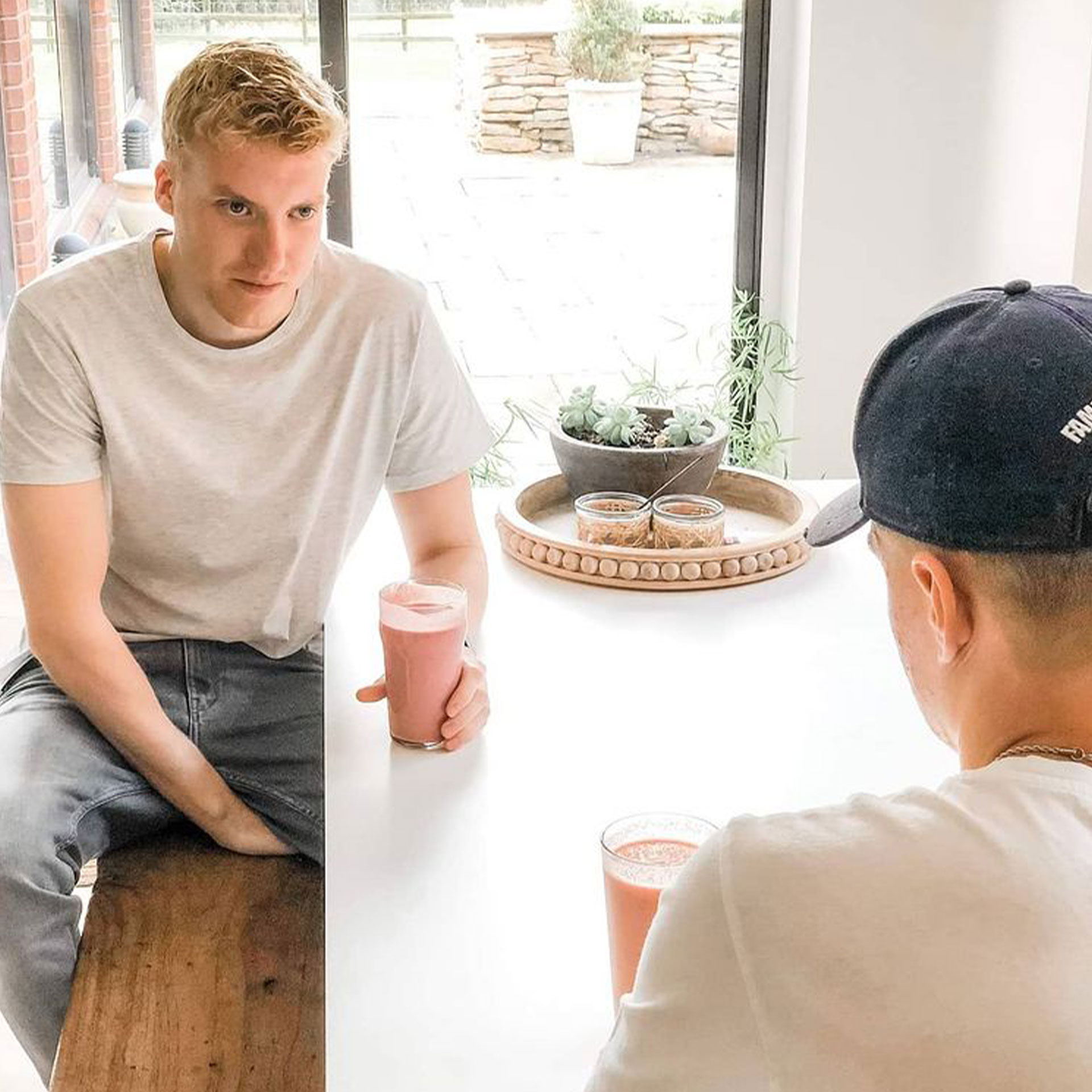 Featured Contributor, Ninka-Bernadette Mauritson's son Bertram, sits at a table holding the smoothie that started his transition into healthier alternatives.