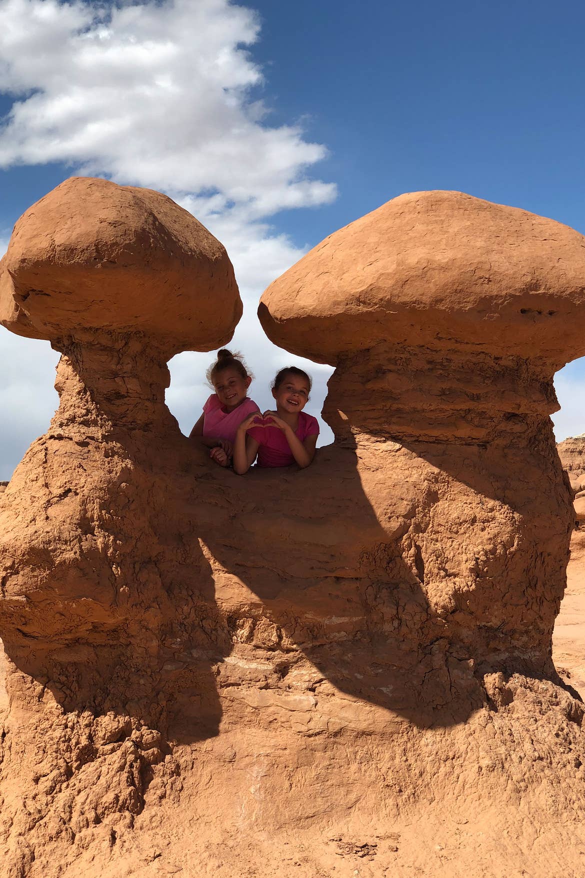 Kyler (left) and Kyndall (right) stand in-between the 'Sandcastle' rock formation at Goblin Valley State Park.