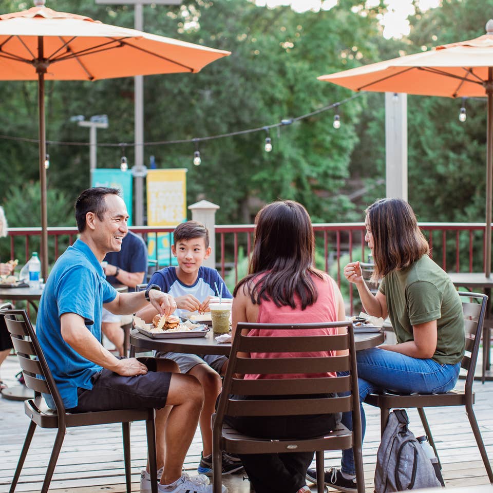 Family of four eating on patio of Grill at Villages Resort in Flint, Texas.