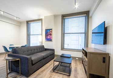 Two bedroom villa living area with couch, two windows and TV at New Orleans Resort in Louisiana.