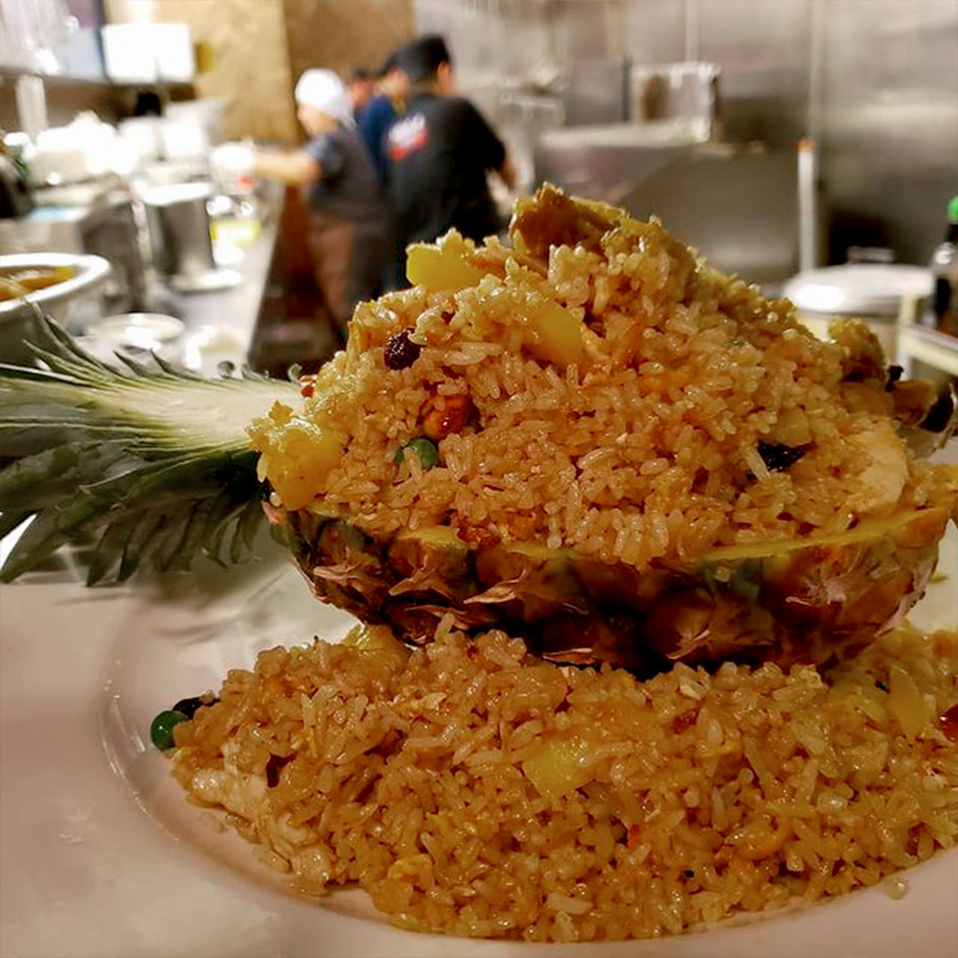 Pineapple fried rice on a plate sitting in the expo window of the kitchen ready to be served.