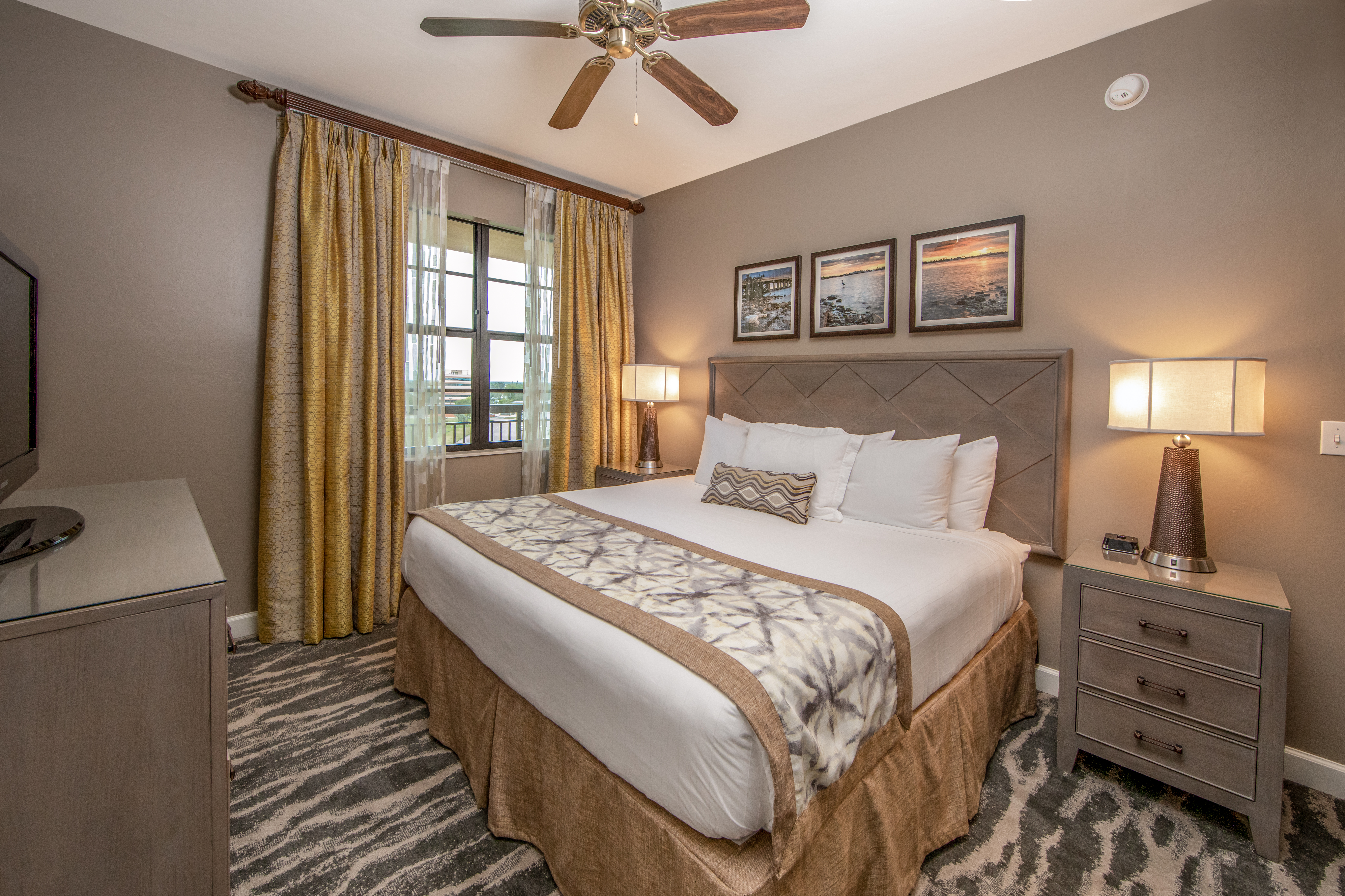 Bedroom with king bed, large window, and ceiling fan in a three-bedroom villa at Sunset Cove Resort in Marco Island, Florida