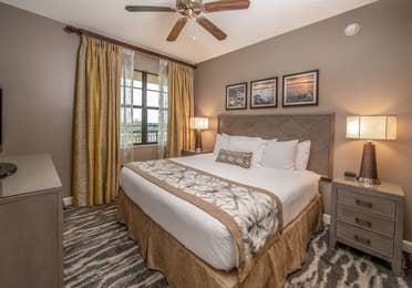 Bedroom with king bed, large window, and ceiling fan in a three-bedroom villa at Sunset Cove Resort in Marco Island, Florida