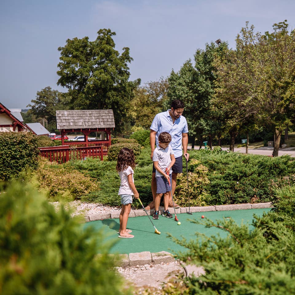 Family playing mini golf at Fox River Resort in Sheridan, Illinois.