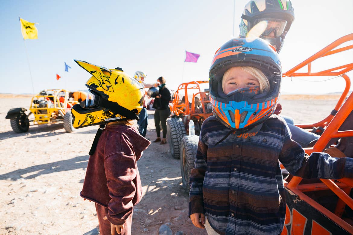 The Haby kids wear safety helmets next to their Sunbuggy in the sandy dunes near our Desert Club Resort located in Las Vegas, Nevada.