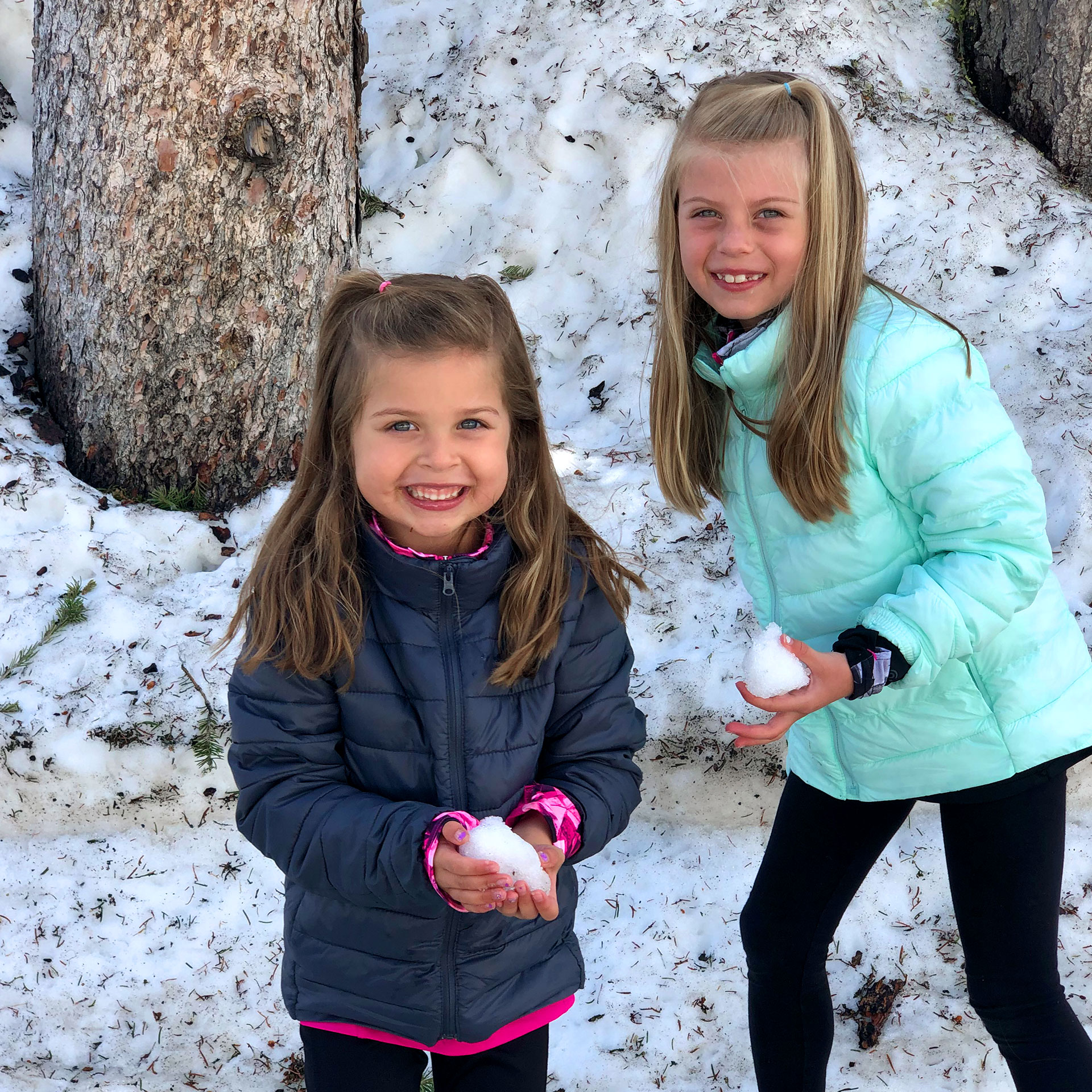 Author, Chris Johnstons' daughters, Kyndall (right), and Kyler (left) play in the snow at Mt. Washburn wearing winter coats.
