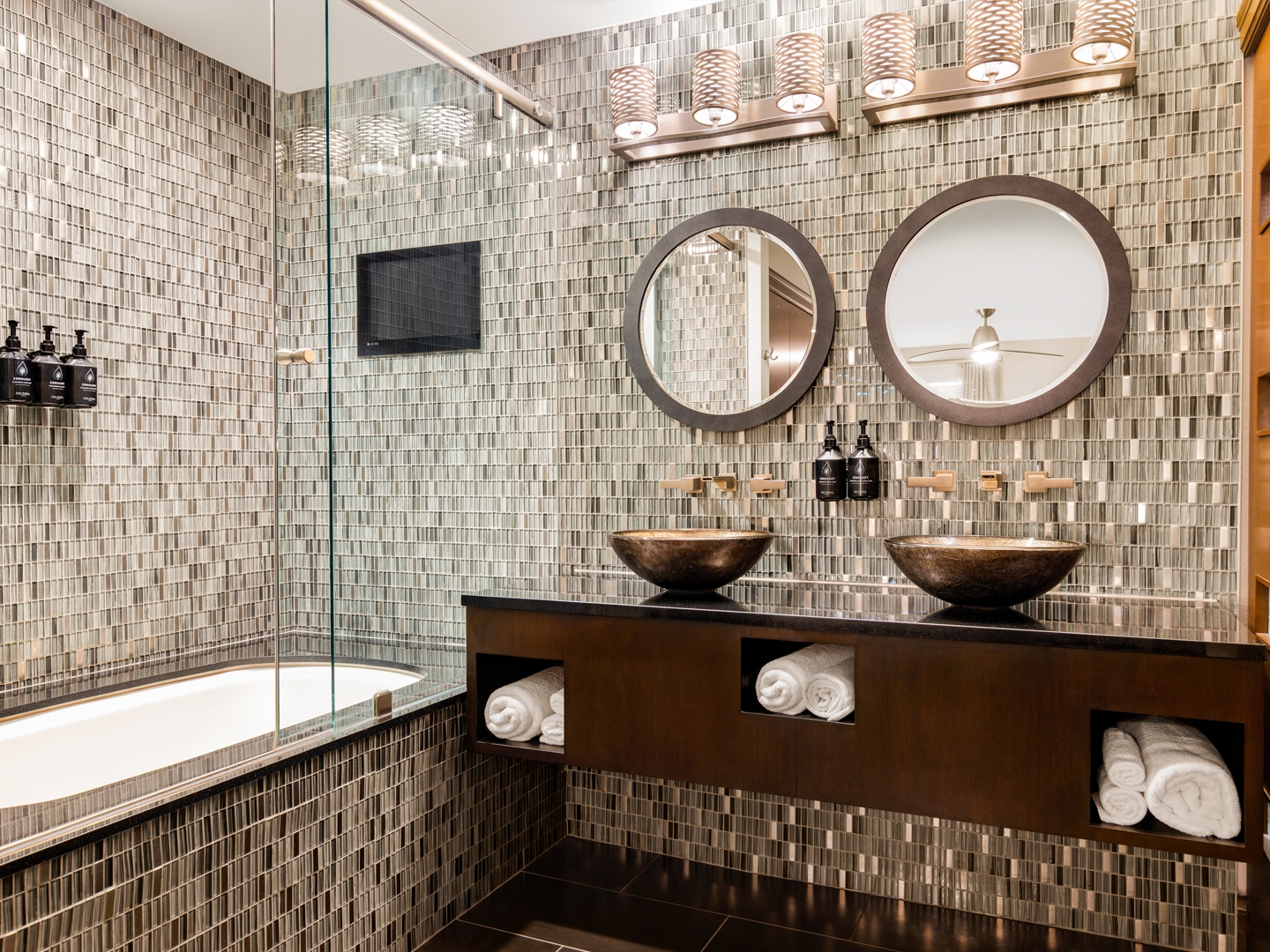 Modern bathroom with glass shower and gold accents.
