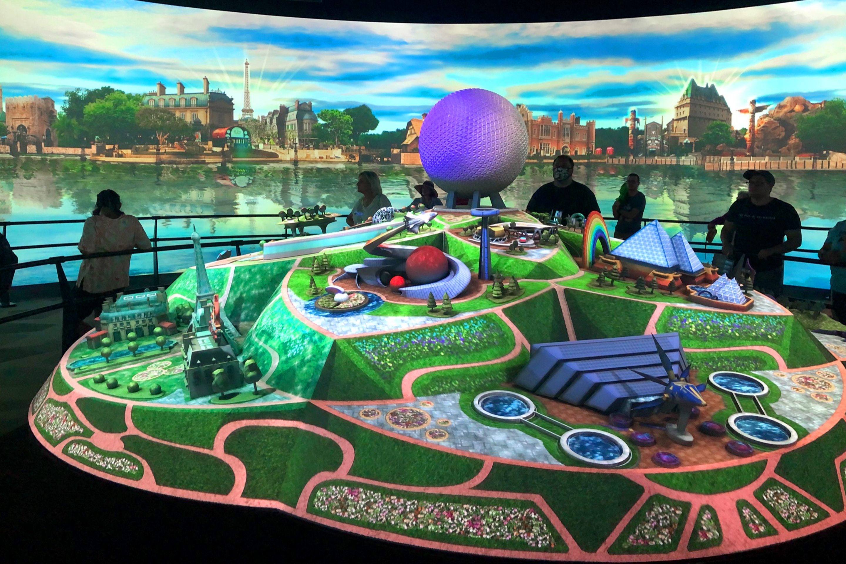 A wall of LED panels showing the World Showcase near a scaled model of  Epcot with projection mapped graphics