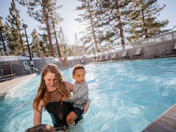 Mother and son in outdoor pool surrounded by trees at Tahoe Ridge Resort in Stateline, Nevada.