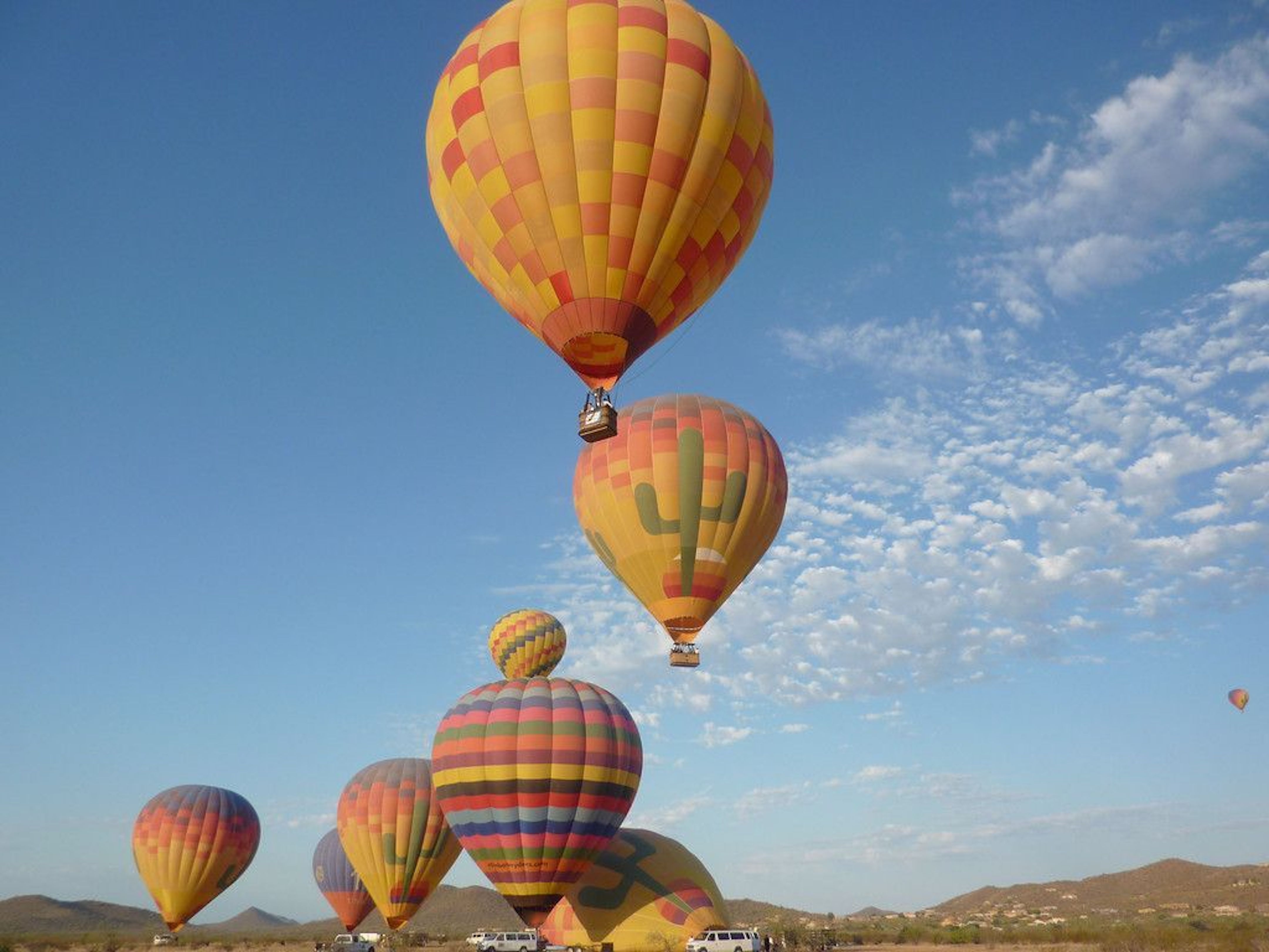 A few hot air balloons flying in the Arizona sky.