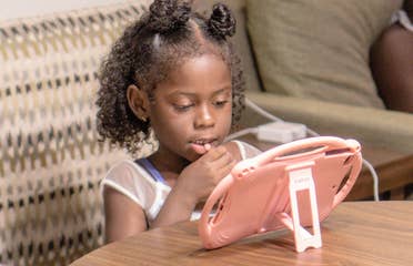 Author, Kimberly Gelin's daughter (left), sits at her dining table in our Villa at Orange Lake Resort in Florida with her iPad for virtual learning.