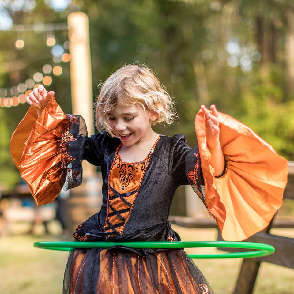 Child hula-hooping in a Halloween costume.