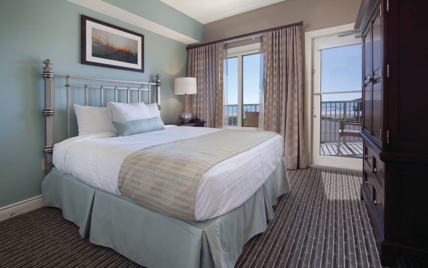 Master bedroom with access to furnished balcony in a two-bedroom villa at Galveston Beach Resort
