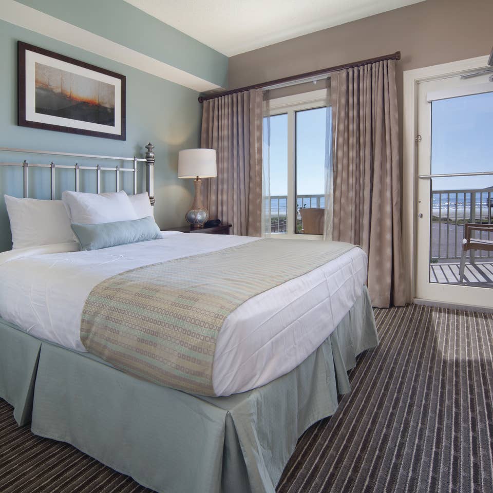 Master bedroom with access to furnished balcony in a two-bedroom villa at Galveston Beach Resort