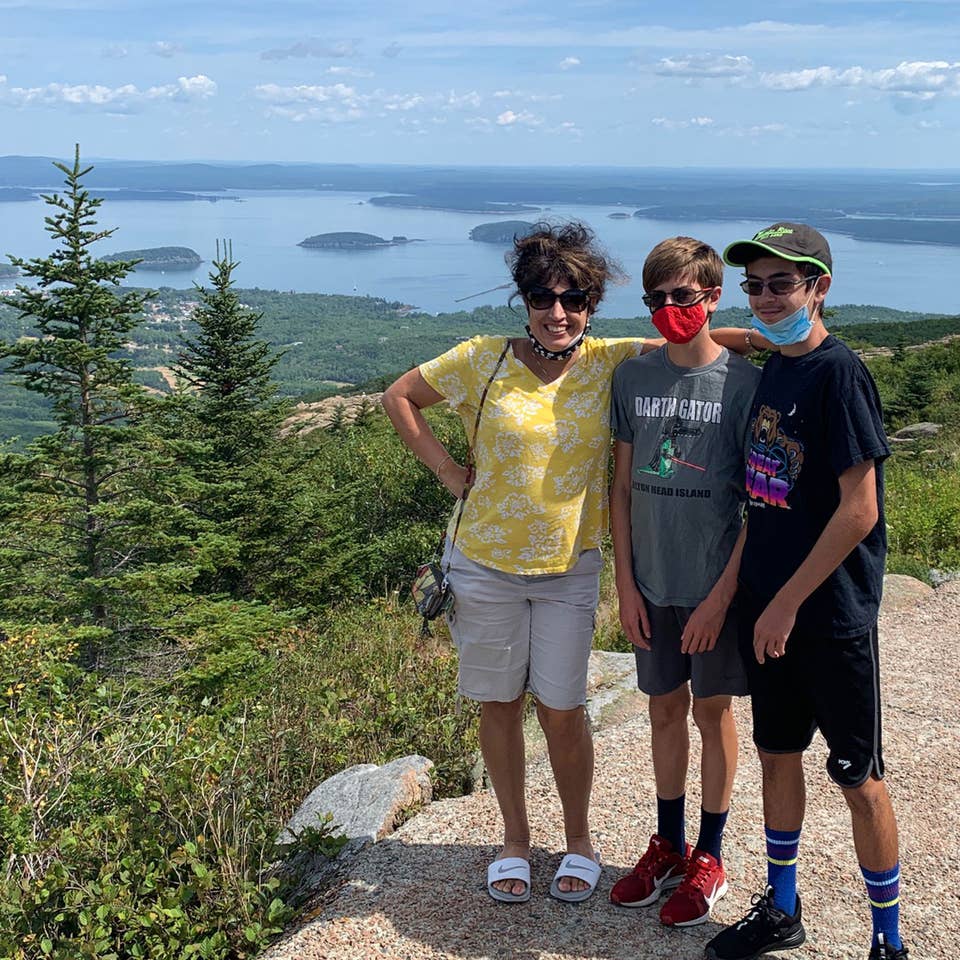 Author, Jennifer Probst (left), and her sons (middle and right) stand on the edge of the Acadia National Park hiking trail while wearing their masks.