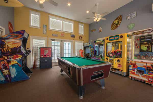Arcade with a billiards table in the center of the room at Galveston Seaside Resort